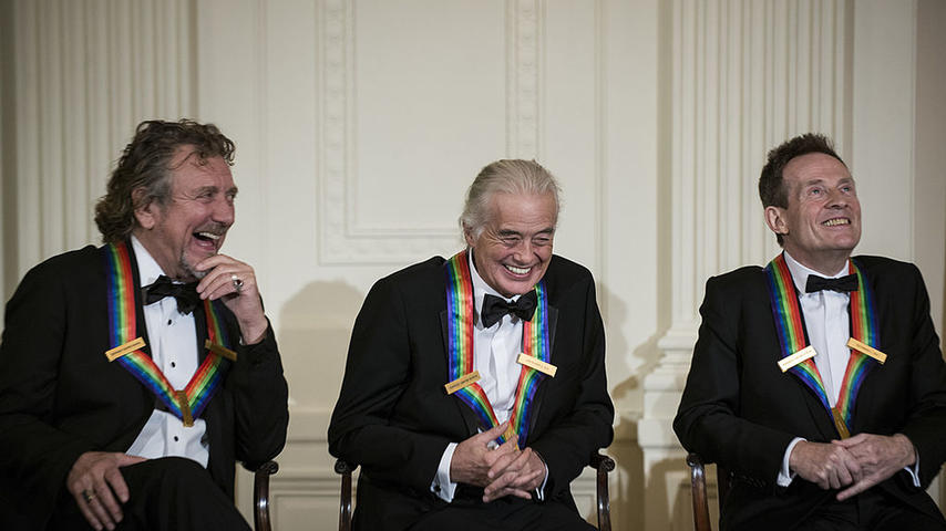 (L-R) Led Zeppelin band members Robert Plant, Jimmy Page, John Paul Jones listen during an event in the East Room of the White House December 2, 2012 in Washington, DC. US President Barack Obama and First Lady Michelle Obama attended the event at the White House with the 2012 Kennedy Center Honorees to celebrate their contribution to the arts before heading to the Kennedy Center for the honors program. AFP PHOTO/Brendan SMIALOWSKI (Photo credit should read BRENDAN SMIALOWSKI/AFP via Getty Images)
